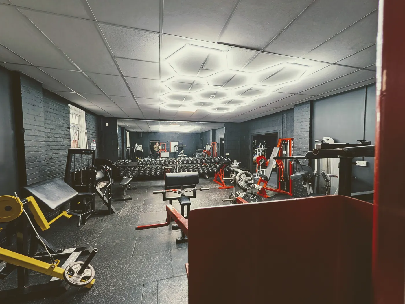Free-weights room with hexagon LED lights, racks and machines