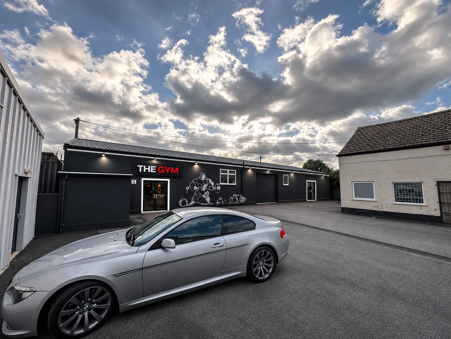 Outside THE GYM on Glanabar Estate, Vale Road, Rhyl, with the black building, THE GYM sign and on-site car park