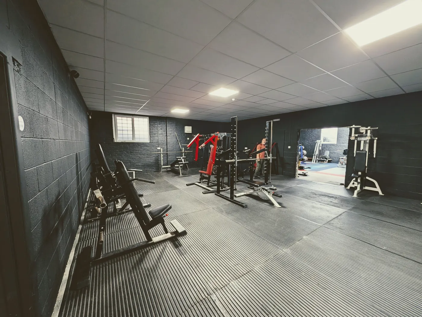 Plate-loaded and cable machines across the matted training floor